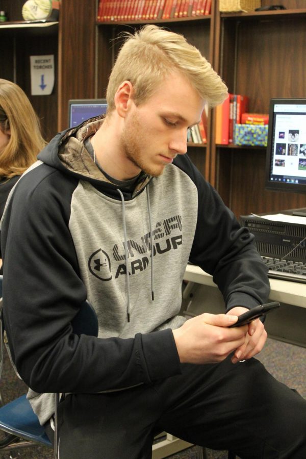 As the lecture continues, Korbin Ridderman pays more attention to his phone rather than class.