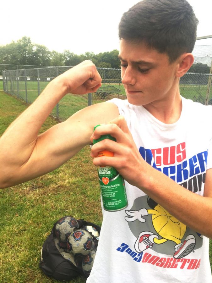 Nathan Faupel 21 sprays bug spray to protect against EEE